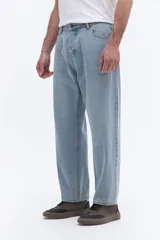 Jean de corte baggy con tiro medio y diseño amplio en piernas y cadera. Cuenta con pasacintos y cierre frontal con botón.