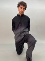 Camisa de lana color gris con cuello mao, corte recto y mangas largas con detalle texturizado. Presenta cierre invisible en el escote superior y tajos laterales.