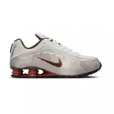 Championes Nike Shox R4, color blanco con detalles en gris, marrón y rojo en las columnas de amortiguación.
