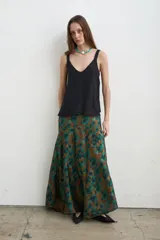 Falda larga irregular de seda con estampado en tonos marrón y verde, corte evasé y caída fluida.