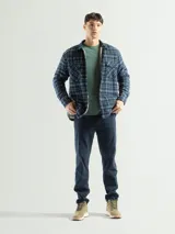 Sobrecamisa de franela a cuadros azul, verde y blanco, con forro de corderito blanco, cuello clásico, cierre frontal con botones, mangas largas y dos bolsillos con solapa abotonada en el pecho.