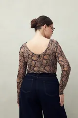 Top de manga larga de tejido translúcido con estampado animal print en tonos marrones, negros y beige.