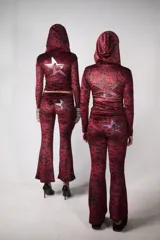 Conjunto de buzo y pantalón de terciopelo rojo con estampado animal print negro. El buzo es de corte ajustado, con capucha y cierre frontal. El pantalón es de corte acampanado y tiene un aplique de estrella de strass en la parte trasera.