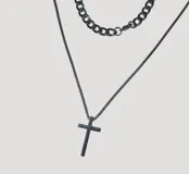 Conjunto compuesto por un collar con dije de cruz y una pulsera de cadena gruesa de eslabones, ambos en color negro.