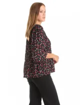 Blusa de gasa con estampado de corazones rojos y blancos sobre fondo negro. Presenta cuello redondo con escote en V, mangas largas con puños fruncidos y un corte holgado con detalle de frunces en la cintura.