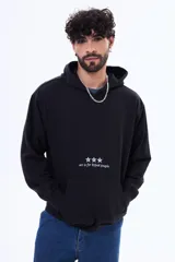 Buzo tipo canguro de felpa color negro, con capucha y bolsillo frontal. Presenta un estampado pequeño en el centro del pecho con tres estrellas y la frase 'art is for hyped people'.