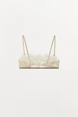 Bralette tipo bandeau confeccionado en encaje con diseño floral, escote recto y tirantes finos ajustables. Presenta cierre posterior con gancho metálico.