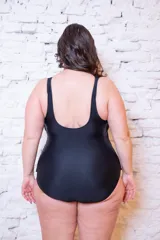 Malla enteriza negra con falda integrada exclusivamente en el frente, escote redondeado y breteles anchos.