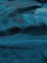 Almohadón cuadrado de lana color beige, con diseño geométrico en relieve. Relleno con funda de algodón, guata y restos textiles.