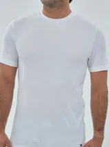 Pack de tres camisetas de cuello redondo y manga corta Tommy Hilfiger, confeccionadas en algodón puro. Incluye una camiseta negra, una blanca y una gris melange, cada una con el logo de la marca bordado en el dobladillo inferior.