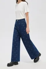 Pantalón de jean azul oscuro de corte ancho, con tiro alto, pinzas frontales y estampado de lunares.