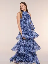 Vestido maxi azul de gasa liviana con estampado abstracto, escote halter fruncido con lazo ajustable, diseño sin mangas, fino cinturón a tono y falda larga con volados escalonados.