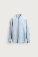 Camisa relaxed fit de denim ligero color celeste, con cuello solapa, manga larga con puños abotonados y cierre frontal de botonadura. Confeccionada con una mezcla de lino y algodón con efecto lavado.
