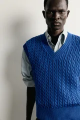 Chaleco de punto trenzado color azul, de corte relaxed fit, con cuello en V y sisas acabadas en rib.