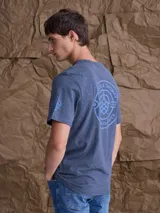 Remera de algodón color azul jaspeado, con cuello redondo, manga corta y estampado pequeño en el pecho.