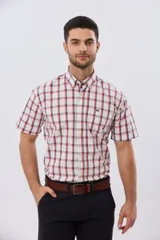 Camisa de manga corta a cuadros en tonos blanco, azul y gris, con cuello abotonado, bolsillo en el pecho y cierre frontal con botones.