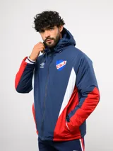 Campera de abrigo Umbro del Club Nacional de Football, con diseño de bloques de color en azul, blanco y rojo. Cuenta con capucha ajustable, cierre frontal y logo de la marca junto al escudo del club en el pecho.