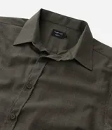 Camisa de manga larga con cuello inglés y cierre frontal de botones, confeccionada en tricolina de algodón color beige.