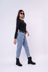 Pantalón de jean estilo mom, de tiro alto y corte recto con ruedos doblados. Presenta un lavado claro y cierre frontal con botón y cremallera.