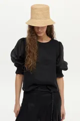 Blusa de lino blanca con escote redondo y mangas cortas abullonadas con detalles de volados en los puños.