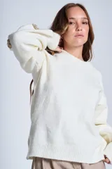 Sweater color crema de hilado frizado con cuello redondo y apliques de flores color beige en las mangas.