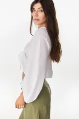 Top de lino italiano color beige, con escote en V, mangas abullonadas y cordón ajustable en el centro del frente.