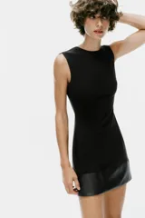 Vestido mini negro sin mangas, de cuello redondo, con detalle de tejido efecto piel combinado a tono en el bajo. Cuenta con forro interior y cierre en la espalda con cremallera oculta.