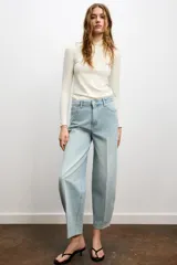 Jeans de tiro medio con corte tapered y largo completo. Presentan diseño de cinco bolsillos, trabillas en la cintura y cierre frontal con cremallera y botón, con un acabado de efecto lavado.