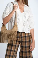 Blusa color crudo de manga corta abullonada, con escote en V y detalles de encaje y bordados verticales en el frente y mangas.