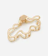 Pinza para el pelo de metal dorado con diseño de estructura ahuecada y líneas orgánicas onduladas.