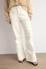 Pantalón de jean wide leg en color blanco, de tiro alto y corte ancho con dobladillo ancho en los bajos.