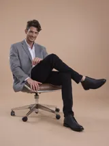 Blazer formal color negro, confeccionado en tela texturada, con solapas clásicas, cierre de dos botones frontales y bolsillos con solapa.