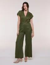 Enterito largo de lino verde militar con escote en V cruzado, mangas cortas japonesas, cintura entallada con cinturón y hebilla metálica, y pantalón de corte recto con bolsillos laterales.