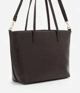 Cartera tipo shopper de gran tamaño, confeccionada en poliuretano con textura efecto crocco. Presenta doble asa fija para llevar al hombro y una correa larga desmontable con herrajes dorados. Cuenta con cierre superior por cremallera.