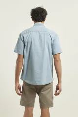 Camisa de jean celeste de manga corta con cuello abotonado y bolsillo en el pecho.