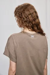 Remera negra de manga corta con cuello redondo y silueta amplia, de hombros caídos y textura suave.