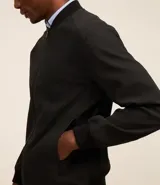 Campera negra de poliéster con cuello mediano, cierre por cremallera, manga larga con ajustes y bolsillos. Cuenta con tecnología repelente al agua.