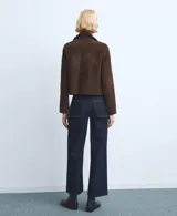 Pantalón de jean azul oscuro de corte recto y tiro alto, con costuras a la vista en color contrastante y ruedo desflecado.
