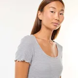 Camiseta de punto canalé a rayas horizontales grises y blancas, con cuello redondo y mangas cortas con terminación ondulada.