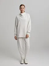 Sweater jogger largo color crema con cuello tortuga.