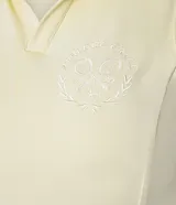 Vestido deportivo evasé color amarillo claro, confeccionado en microfibra. Presenta cuello polo con escote en V, diseño sin mangas y short interno incorporado con bolsillo lateral.