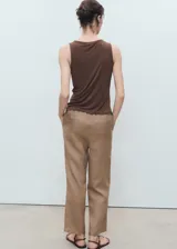 Pantalón recto color beige de lino, con cintura elástica y cordón ajustable, tiro medio y bolsillos laterales.