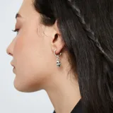 Dije plateado en forma de calavera con gancho para colgar.