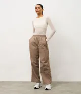 Pantalón deportivo de corte recto confeccionado en microfibra color marrón, con cintura elástica y recortes laterales en tule.