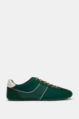 Zapatilla deportiva estilo running color verde, con combinación de materiales, pespuntes decorativos, cordones y talonera en contraste.