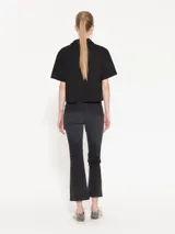 Pantalón de jean negro cropped, de tiro medio y corte acampanado.