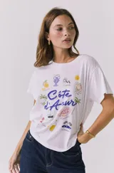 Remera blanca de manga corta con estampado gráfico alusivo a la Costa Azul y la Riviera francesa.