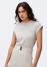 Camiseta sin mangas de tejido de punto fino, color gris claro, con cuello redondo y hombreras sutiles que aportan estructura.