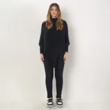 Poncho gris con flecos en el borde inferior, cuello alto y corte asimétrico.