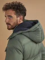 Campera puffer verde militar con capucha, cierre frontal, bolsillos laterales con cierre y un bolsillo de solapa en el pecho.